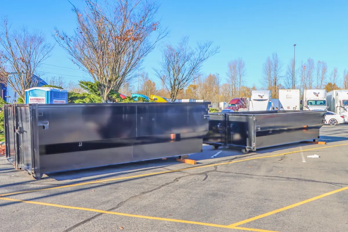 Professional dumpster rental service with roll-off container on residential driveway in Port Allen